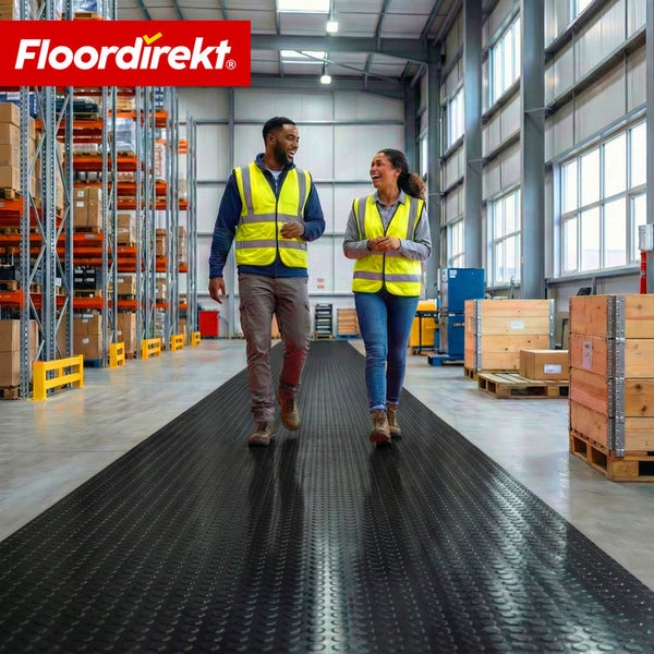 Zwei Personen gehen auf einer genoppten Gummimatte in einem Lagerhaus. Floor direkt Logo.
