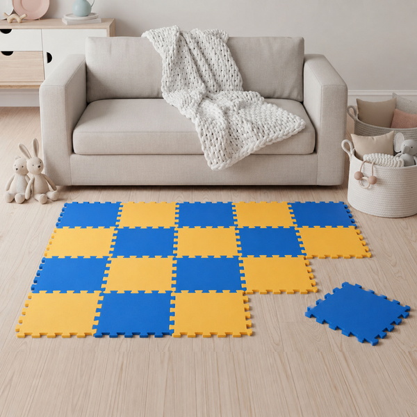 Bunte Spielmatte aus Schaumstoff mit Stecksystem, verlegt in einem Wohnzimmer vor einem Sofa auf einem Boden aus Holz.