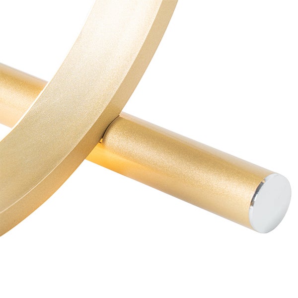 Detailaufnahme einer goldenen Lampe mit runder und eckiger Form.