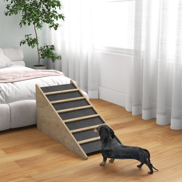 Holz-Hunderampe mit rutschfester Oberfläche und Stufen vor einem Bett in einem hellen Schlafzimmer mit einem Dackel.
