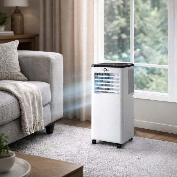 Mobiles Klimagerät von Sannover in einem hellen Wohnzimmer neben einem Sofa und einem Fenster.