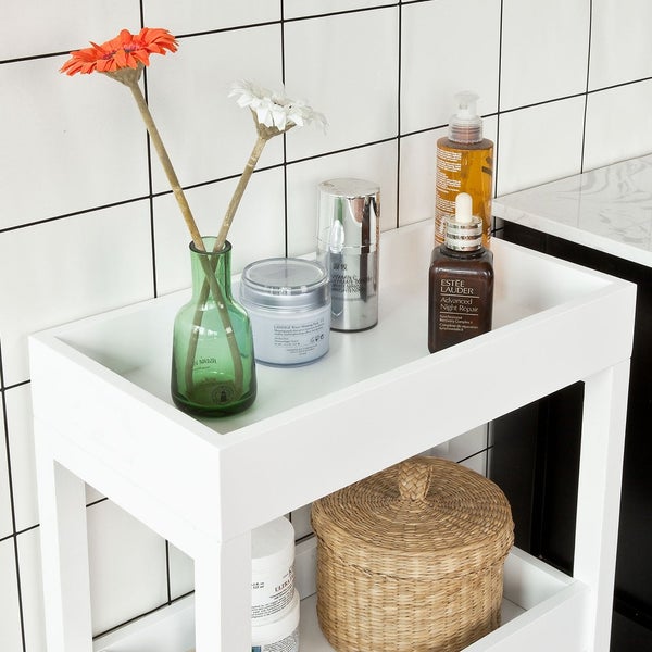 Badezimmerregal mit Kosmetikprodukten, Vase und Korb für Badezimmerzubehör