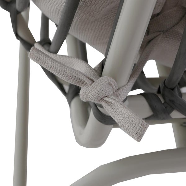 Detailaufnahme eines Sitzkissens, das mit einem Stoffband am Stuhlgestell festgeknotet ist.