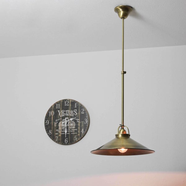 Hängelampe mit konischem Schirm neben einer Wanduhr im Vintage-Stil.