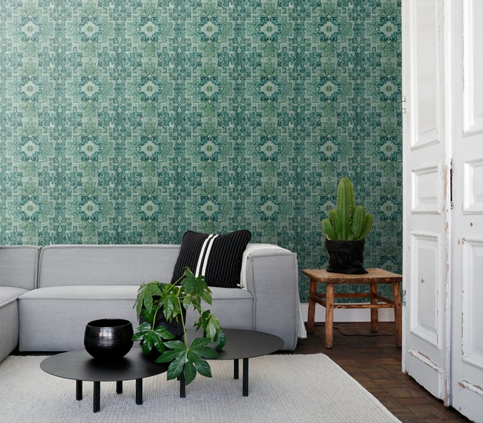 Wohnzimmer mit grauer Couch und Wandtapete mit floralem Muster