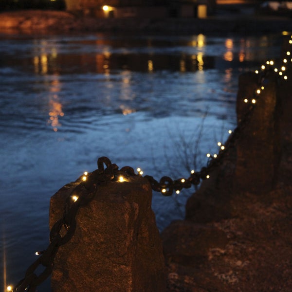 Dekorative Lichterkette an einer Kette, die an Steinpfosten befestigt ist