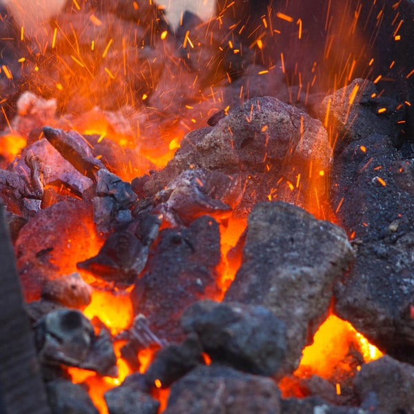 Glühende Holzkohle in einem Grill mit aufsteigenden Funken