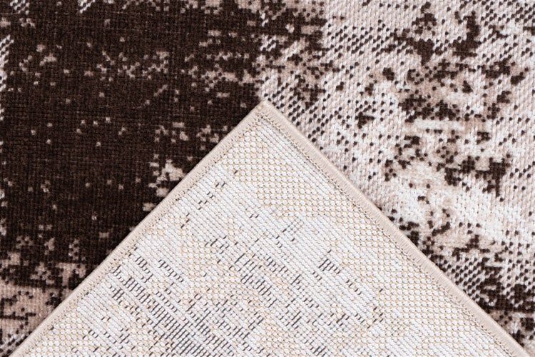 Nahaufnahme eines Teppichs mit Vintage-Muster und umgeklappter Ecke, die die gewebte Rückseite und die verstärkte Kante zeigt.