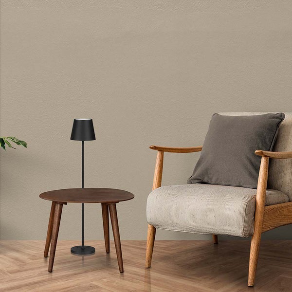 Szene mit einem Sessel, einem runden Tisch und einer Stehlampe