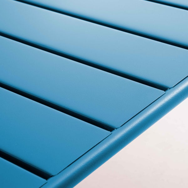 Detailaufnahme eines blauen Möbelbeins aus Metall mit einer schwarzen Schutzkappe.