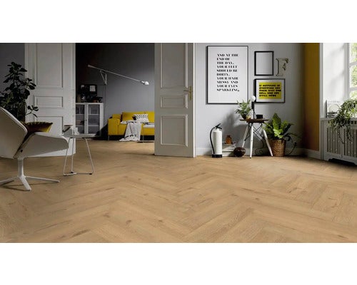 Heller Raum mit verlegtem Laminatboden in Fischgrätmuster, eingerichtet mit Sitzgelegenheit und Dekoartikeln