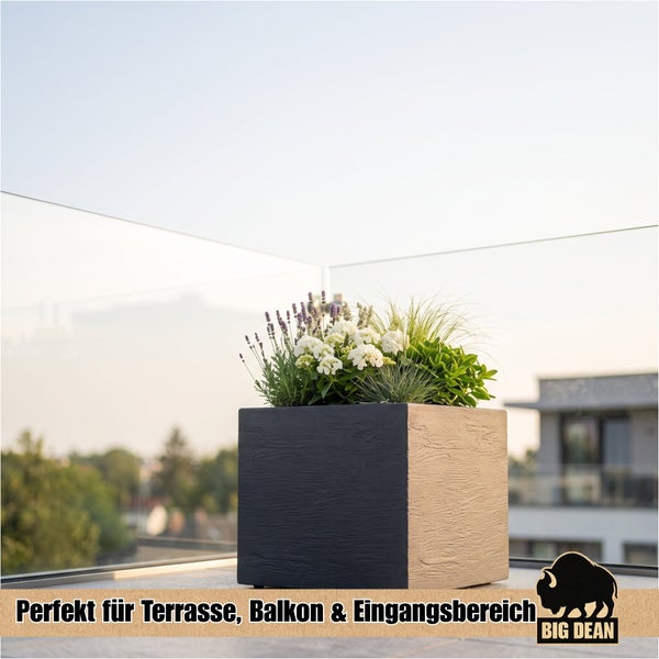 Quadratischer Pflanzkübel mit strukturierter Oberfläche, bepflanzt mit Blumen und Gräsern, auf einer Terrasse, Big Dean Logo.