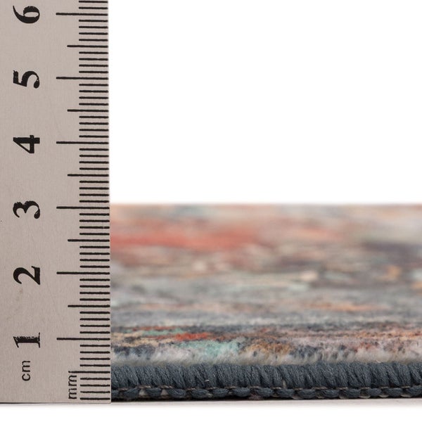 Nahaufnahme einer Teppichkante mit einem Lineal zur Messung der Florhöhe von etwa einem Zentimeter.