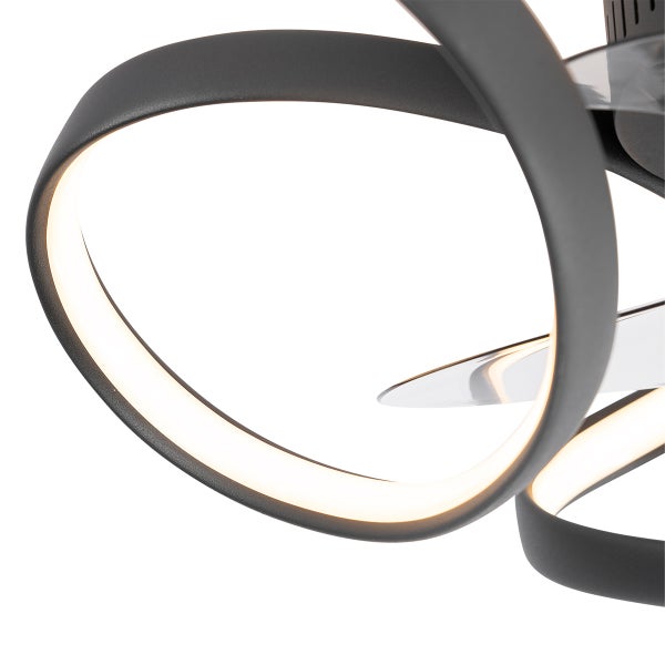 Nahaufnahme eines modernen Deckenventilators mit geschwungener LED-Beleuchtung und transparenten Flügeln.