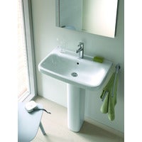 Modernes Waschbecken mit Standsäule aus Keramik inklusive Einhebelmischer, Wandspiegel und Handtuchhalter in einem hellen Badezimmer.