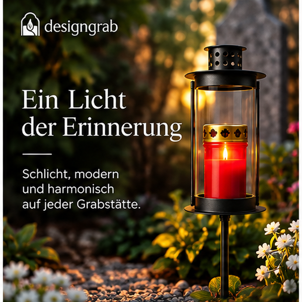 Moderne Grablampe mit brennender Grabkerze auf einem Stab in einem Friedhofsgarten.