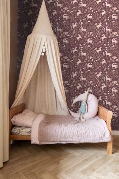 Kinderzimmer mit Bett, Baldachin und Tapete mit Einhornmuster