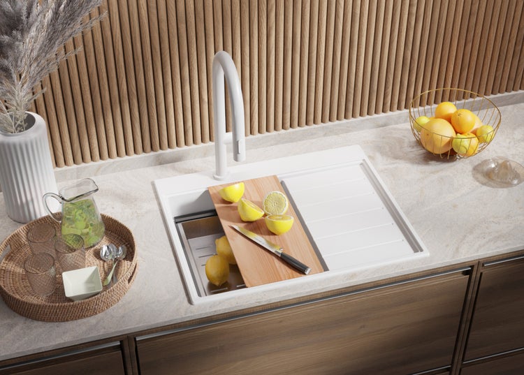 Küchenszene mit Spüle, Armatur, Gemüse und Kräutern