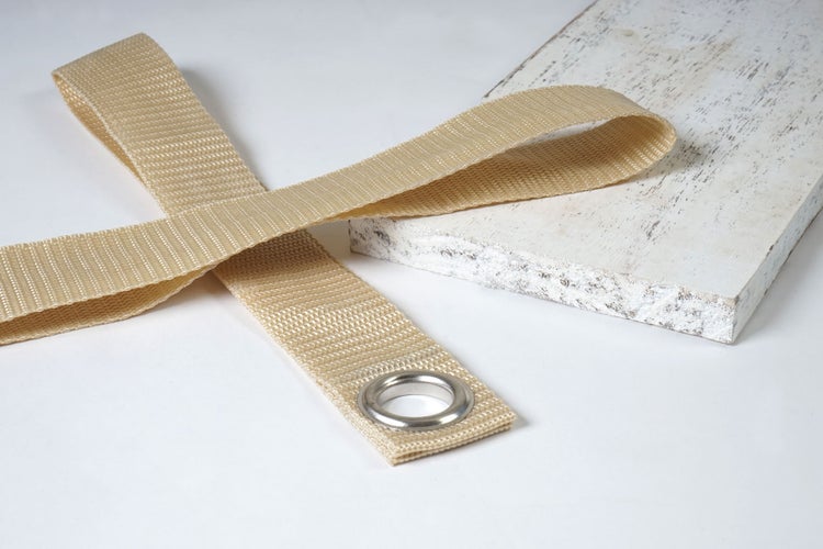 Textilband mit Öse auf Holzbrett