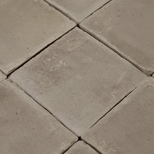 Quadratische Bodenfliesen oder Wandfliesen aus Beton mit rauer Oberflaechenstruktur im Verbund.