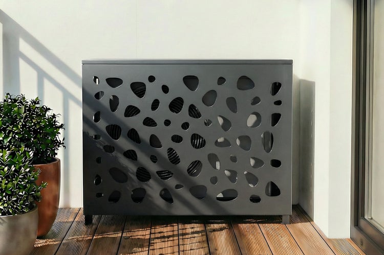 Graue Klimaanlagenverkleidung mit Lochmuster auf einer Terrasse.