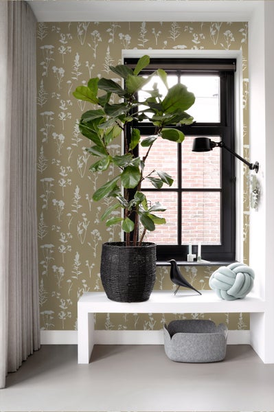 Dekoratives Wohnambiente mit Zimmerpflanze, Tischleuchte und gemusterter Tapete