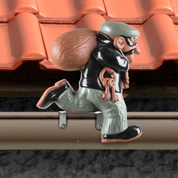 Dachrinnenfigur Einbrecher aus Keramik mit Sack und Schlüsseln, montiert auf Metallhalterung an einer Dachrinne.