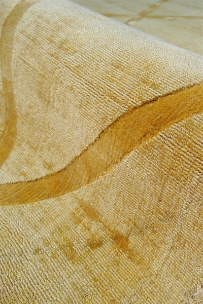 Nahaufnahme eines beigen Teppichs mit strukturierter Oberfläche und geschwungenem Muster.