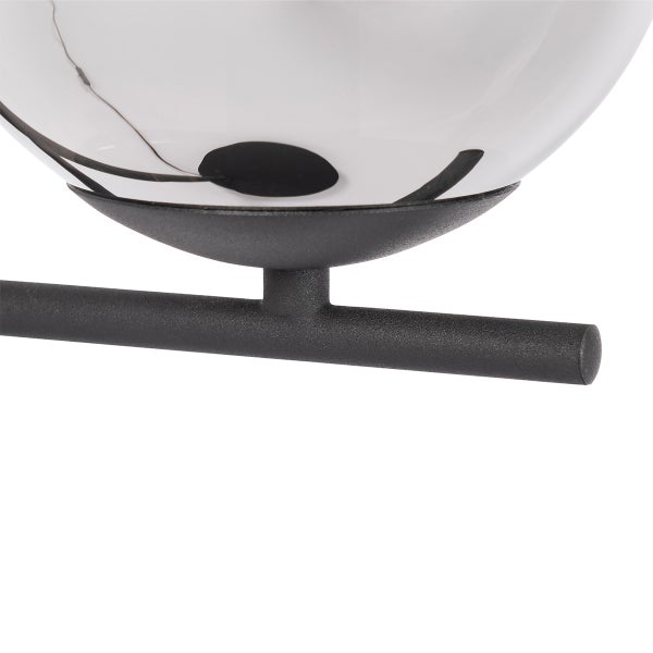 Detailansicht einer Leuchte mit einem runden Lampenschirm und einem Metallfuß