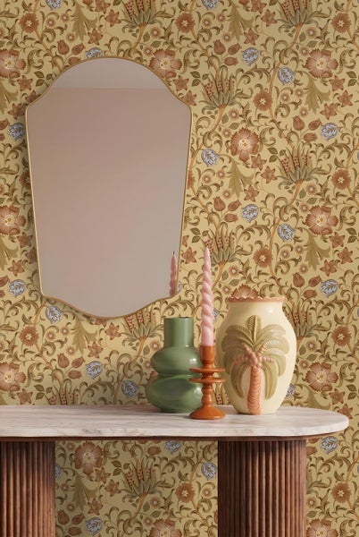 Floral gemusterte Tapete mit Spiegel, Konsolentisch mit Marmorplatte und geriffelten Holzbeinen sowie dekorativen Vasen.