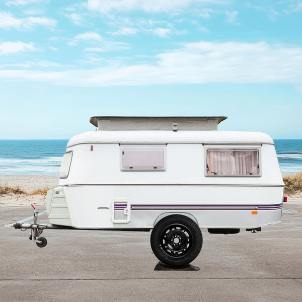 Weißer Wohnwagen auf einem Strandparkplatz