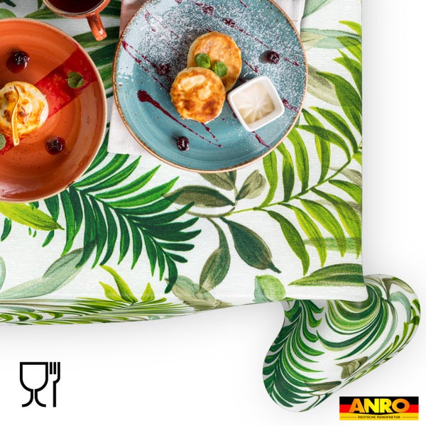Hell gedeckter Tisch mit abwaschbarer Tischdecke mit tropischem Blättermuster, lebensmittelecht, ANRO Logo.