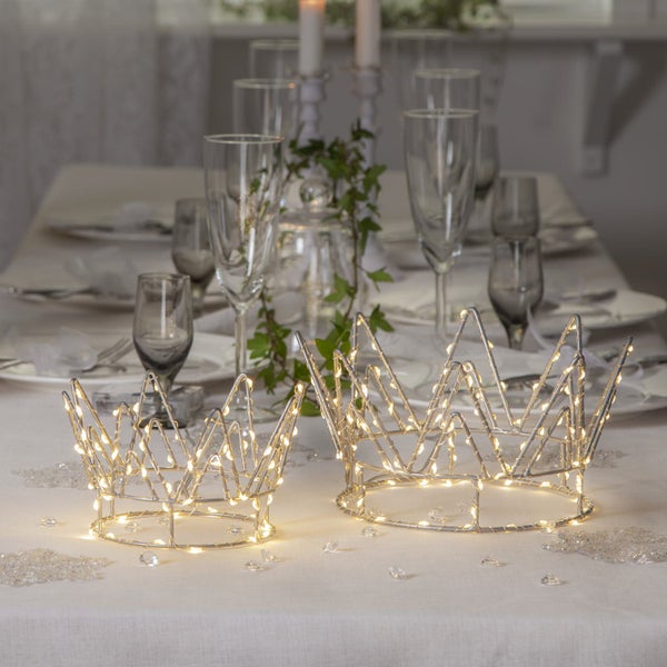 Dekorativer Tisch mit zwei beleuchteten Kronen als Mittelpunkt