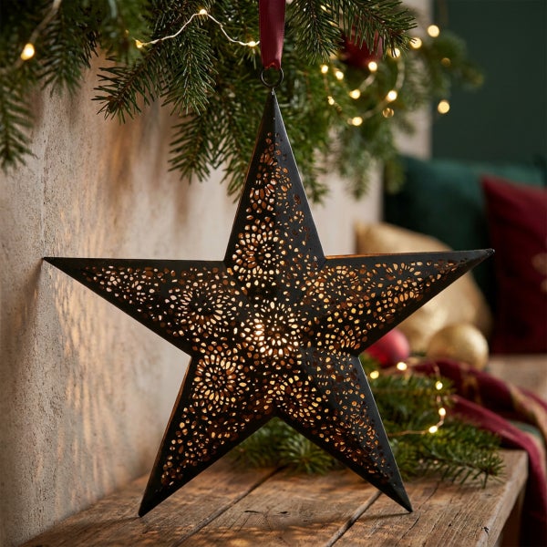 Dekorativer Weihnachtsstern aus Metall mit ausgestanzten Mustern und Beleuchtung zum Aufhängen
