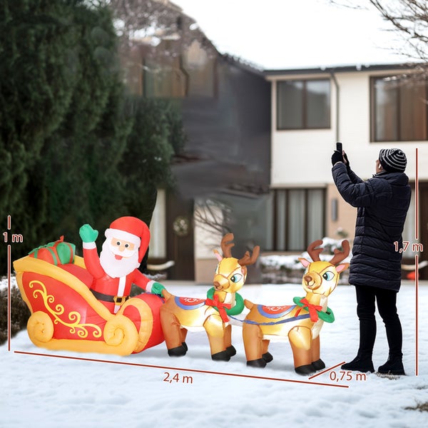 Aufblasbare Weihnachtsdekoration mit Weihnachtsmann im Schlitten und zwei Rentieren im verschneiten Garten, Maße 2,4 mal 0,75 mal 1 Meter.