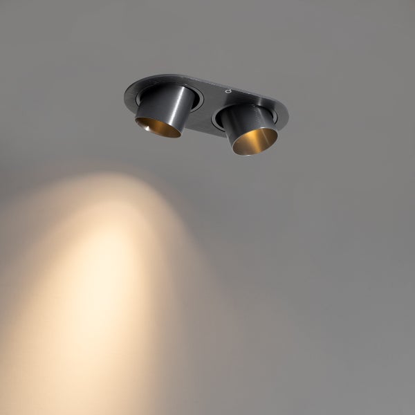 Zweiflammiger Deckenstrahler mit verstellbaren zylindrischen Spotköpfen aus Metall und warmweißem Lichtkegel.