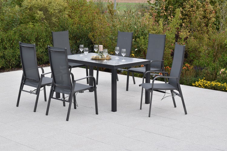 Gartenmöbel-Set aus Aluminium und Textilgewebe mit rechteckigem Tisch und sechs Hochlehner-Stühlen auf einer hellen, weitläufigen Terrasse.