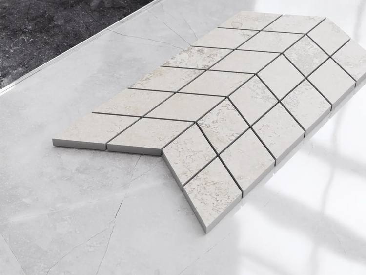 Rautenförmige Mosaikfliesen in Steinoptik, angeordnet in einem Chevron-Muster.