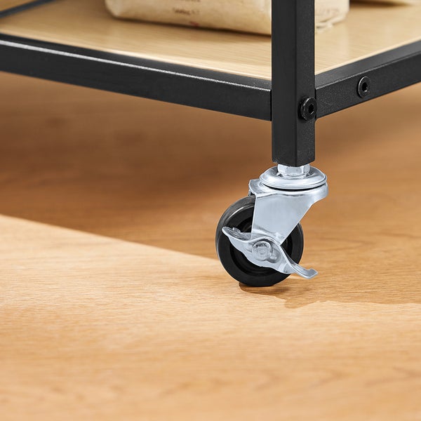 Detailaufnahme eines Möbelstücks mit einem schwarzen Metallgestell und einer Rolle mit Feststellbremse