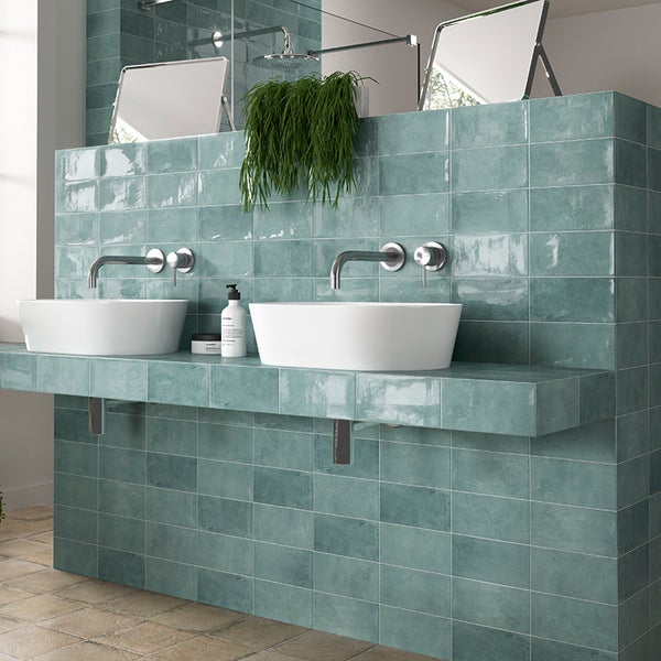 Modernes Badezimmer mit Doppelwaschbecken, montiert auf einem mit glänzenden rechteckigen Fliesen verkleideten Waschtisch.