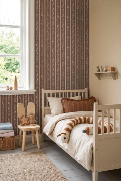 Kinderzimmer mit vertikal gestreifter Blumentapete, Kinderbett aus Holz und Stuhl in Hasenohr-Optik.
