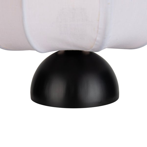 Nahaufnahme eines Lampenfusses in Halbkugelform mit hellem Stoffschirm.