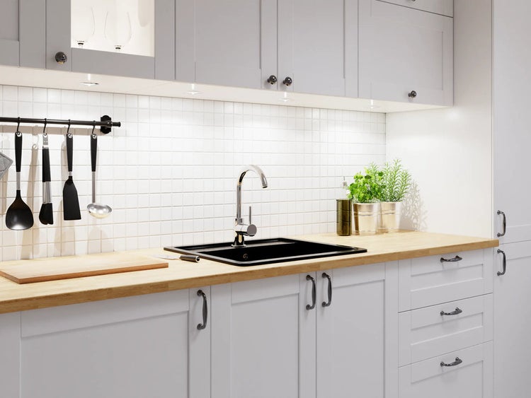 Küchenspüle mit Armatur in einer hellen Küche mit Holzarbeitsplatte