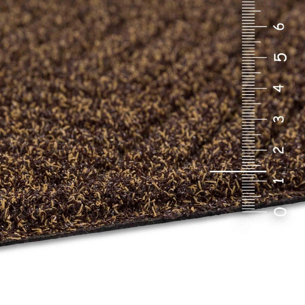 Nahaufnahme eines Kunstrasens mit einer Skala zur Messung der Höhe des Rasens