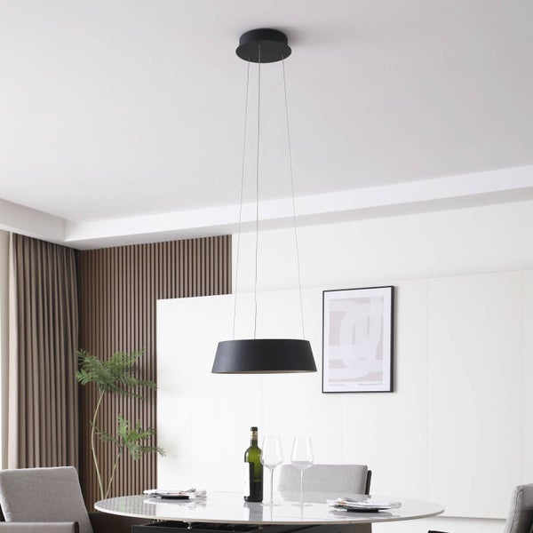 Moderne schwarze Pendelleuchte mit flachem, rundem Schirm über einem Esstisch in einem hellen, modern eingerichteten Esszimmer.