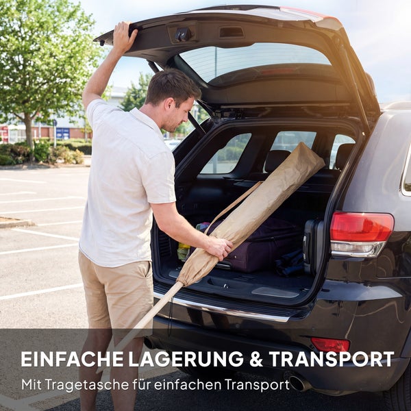 Einfache Lagerung und Transport: Ein Mann verstaut einen Sonnenschirm in einer Tragetasche im Kofferraum eines Autos.