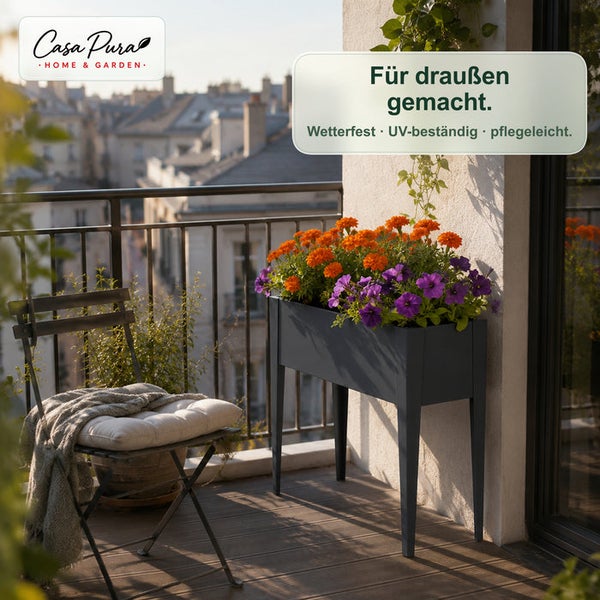 Casa Pura Hochbeet auf Beinen für den Balkon, bepflanzt mit bunten Blumen, neben einem Balkonstuhl.