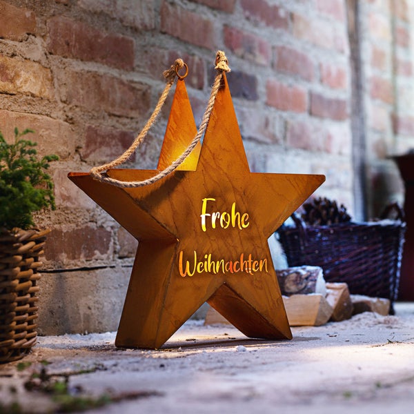 Dekorativer Stern mit der Aufschrift 'Frohe Weihnachten' und einer Seilaufhängung.