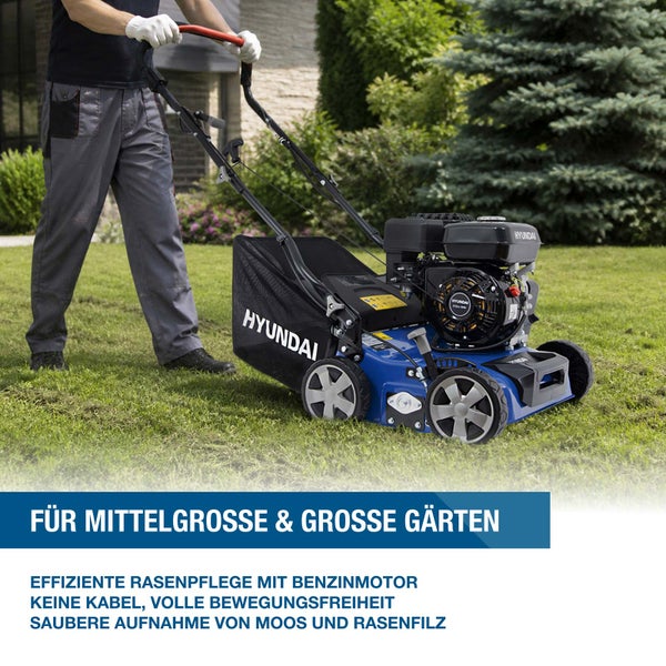 Ein Benzin Rasenlüfter von Hyundai mit Fangkorb in einem Garten zur Rasenpflege.