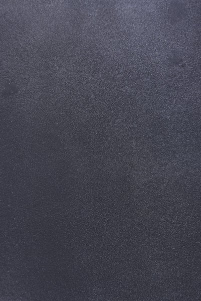 Nahaufnahme einer dunkelgrauen, strukturierten Oberfläche mit feiner körniger Textur.
